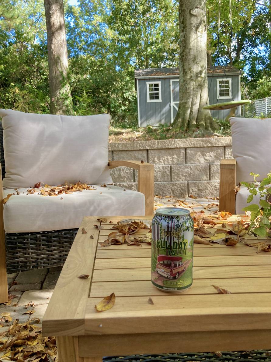 A beer can on an outdoor patio table. The can says “Founder’s All Day IPA Session Ale.”