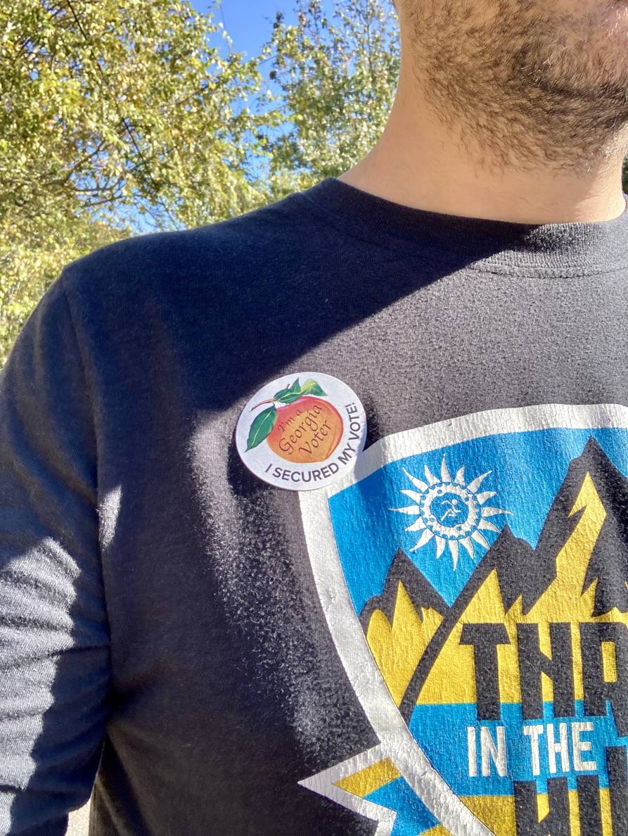 A sticker reading “I’m a Georgia voter / I secured my vote” on a person’s shirt.