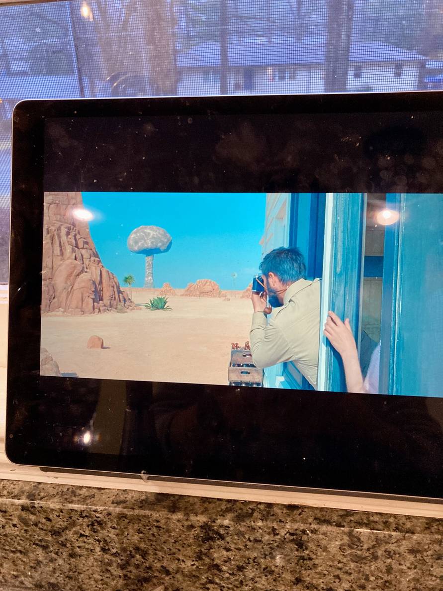 A picture of an iPad playing the movie Asteroid City with a scene of an atomic bomb mushroom cloud.