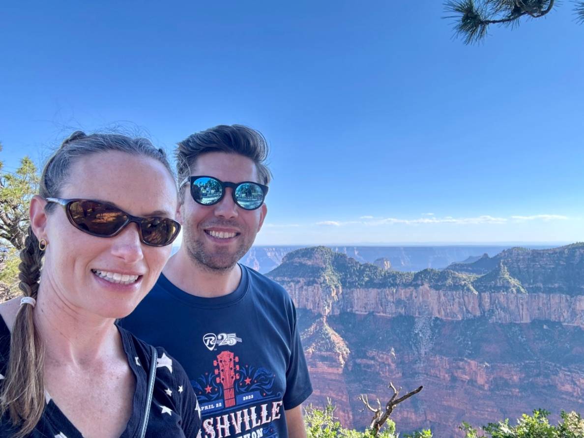 A man and a woman in front of the Grand Canyon.