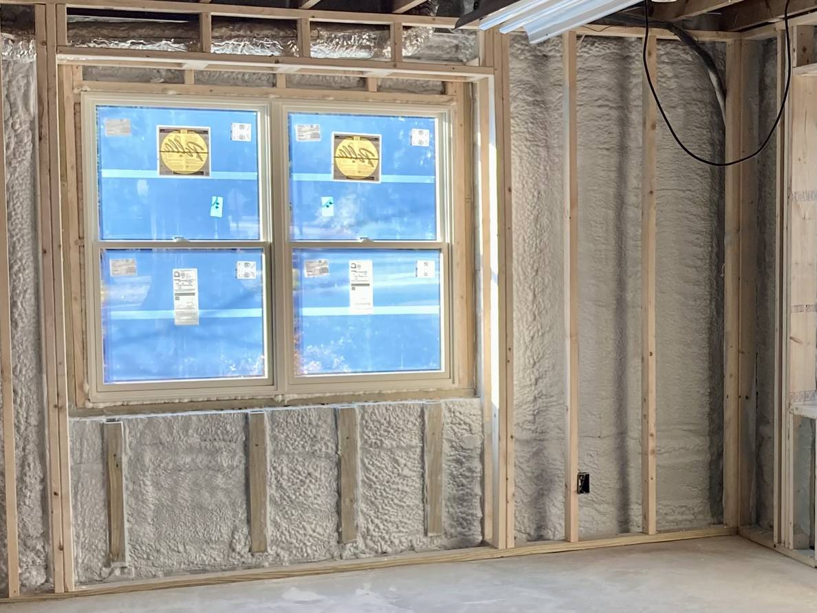 A photo of a basement. The walls are covered in foam insulation.