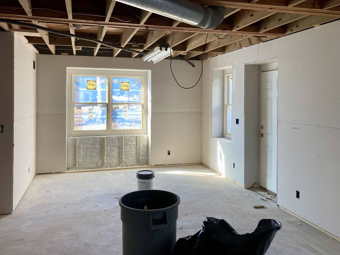 A photo of a partially finished basement room. The walls have drywall, but not yet mudded.