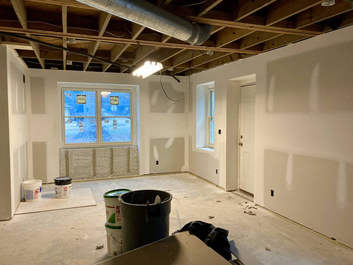 A photo of a partially finished basement with mudded drywalls.