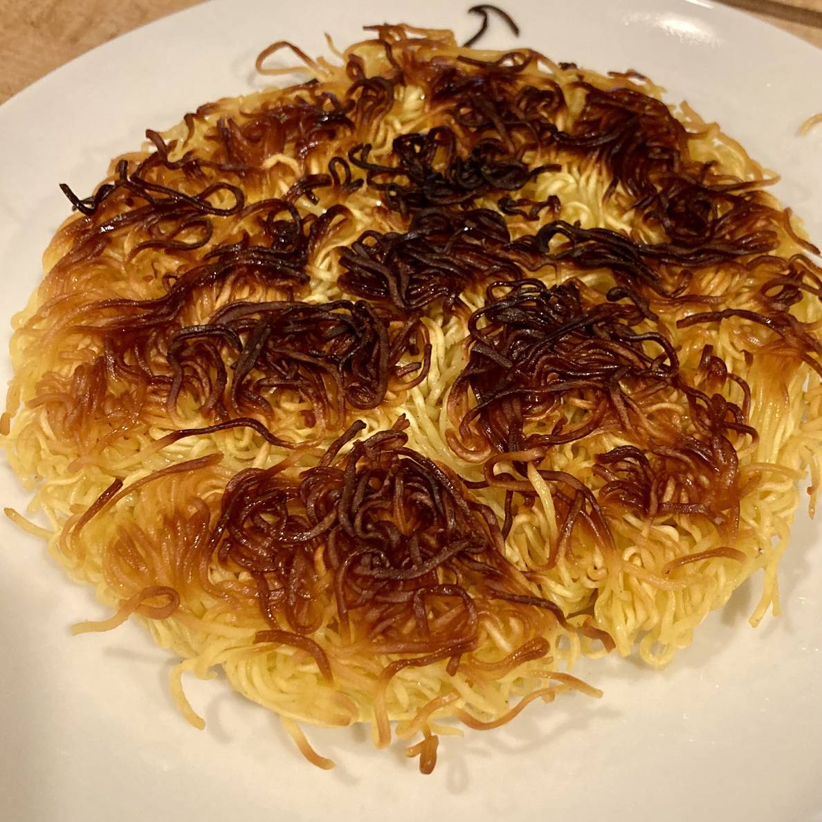 A photo of the noodle cake showing the second cooked side.