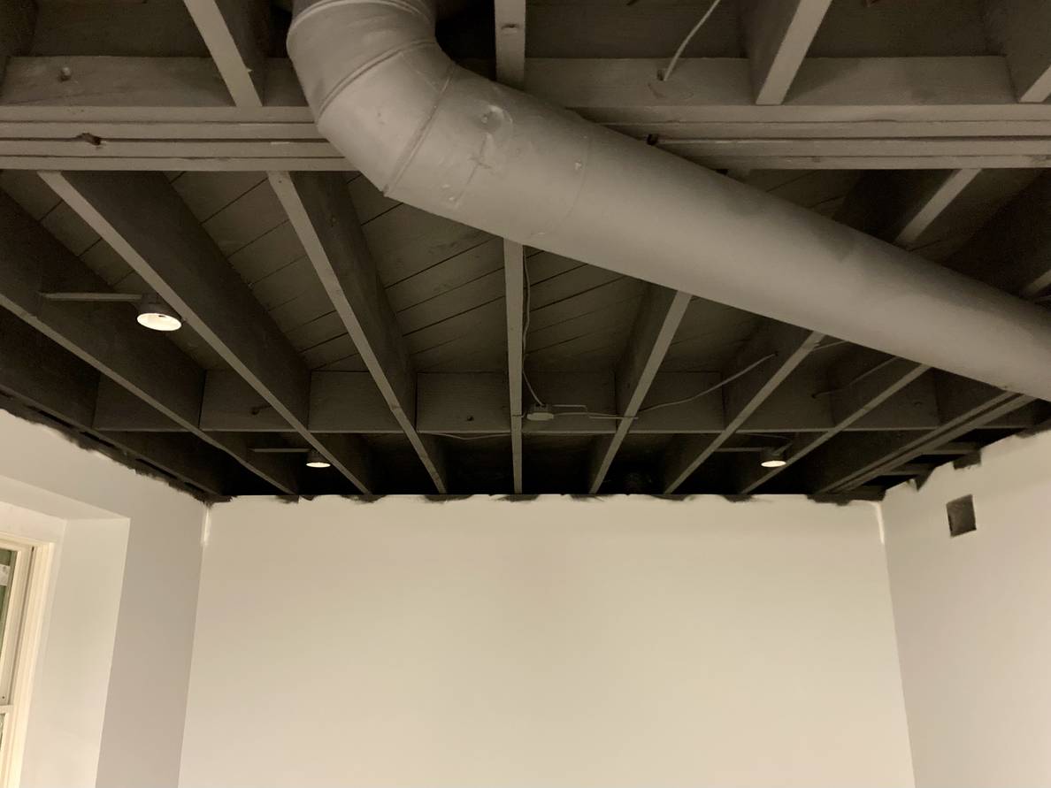 A photo of the newly painted ceiling. It is a charcoal color. The exposed duct work is painted the same color.