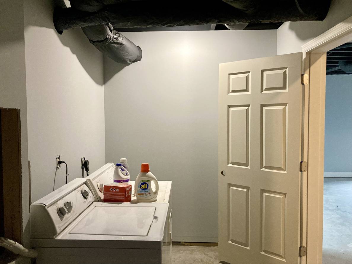 Another photo of the laundry room from a different angle. The visible HVAC duct is painted the same as the ceiling.