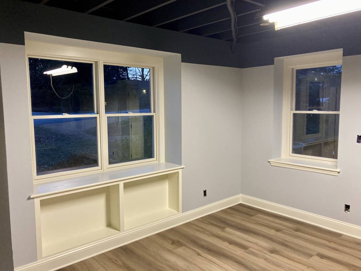 A photo of a mostly finished basement. All of the trim and walls and have been painted.