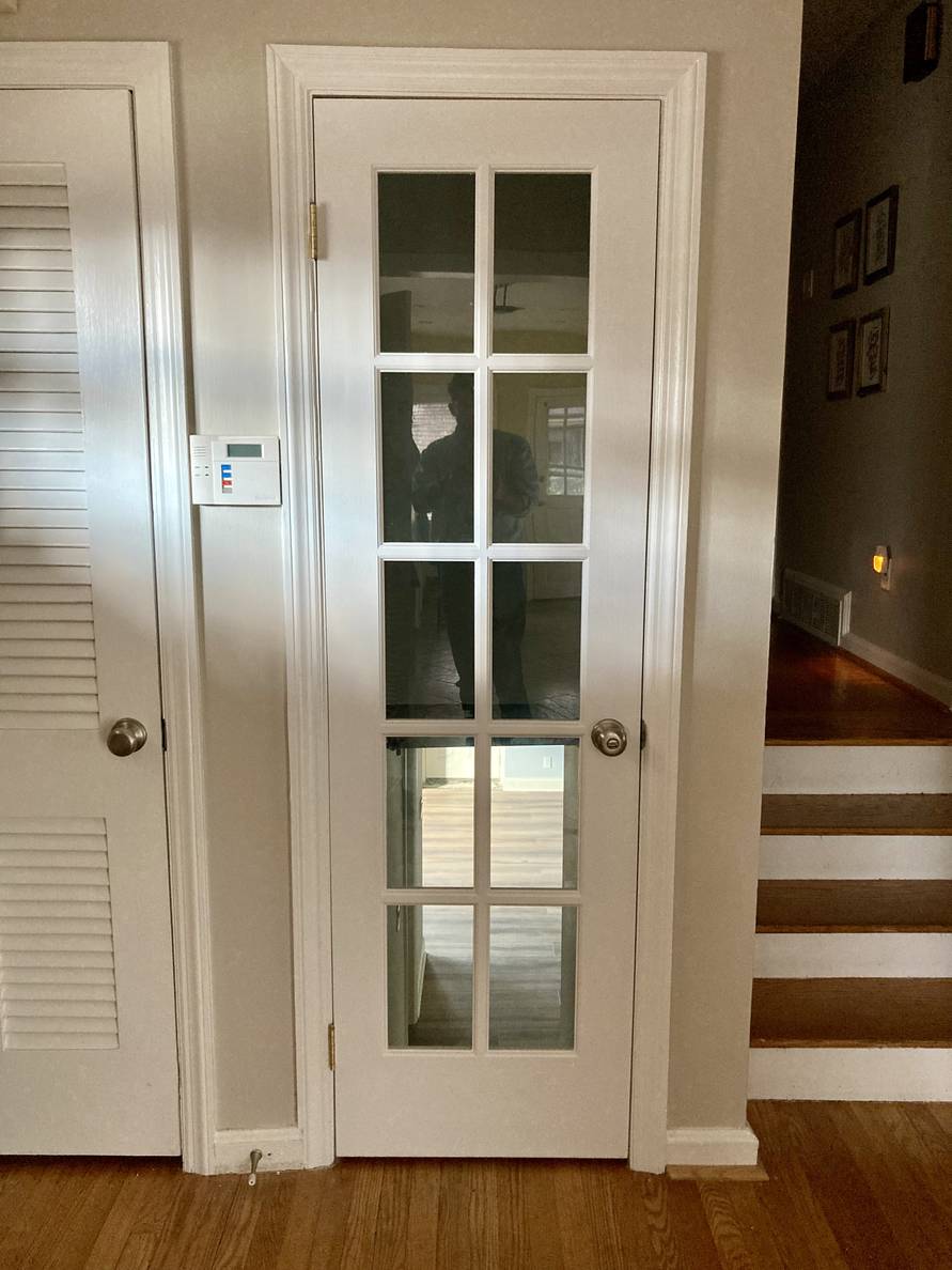 A photo of the new door to the basement from the main floor. It’s a narrow door with window panes in a 2x5 grid.