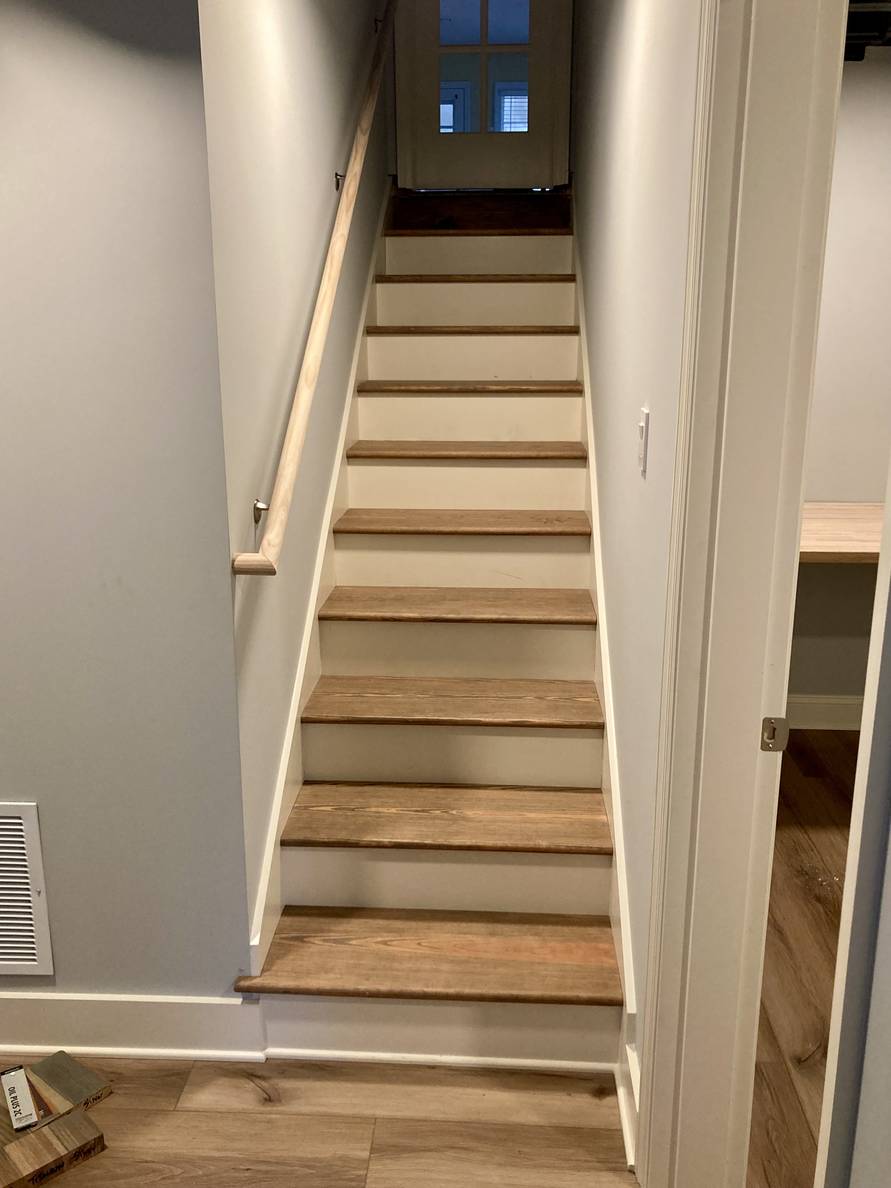 A photo of a stairway with stained-wood treads and a to-be-finished handrail.