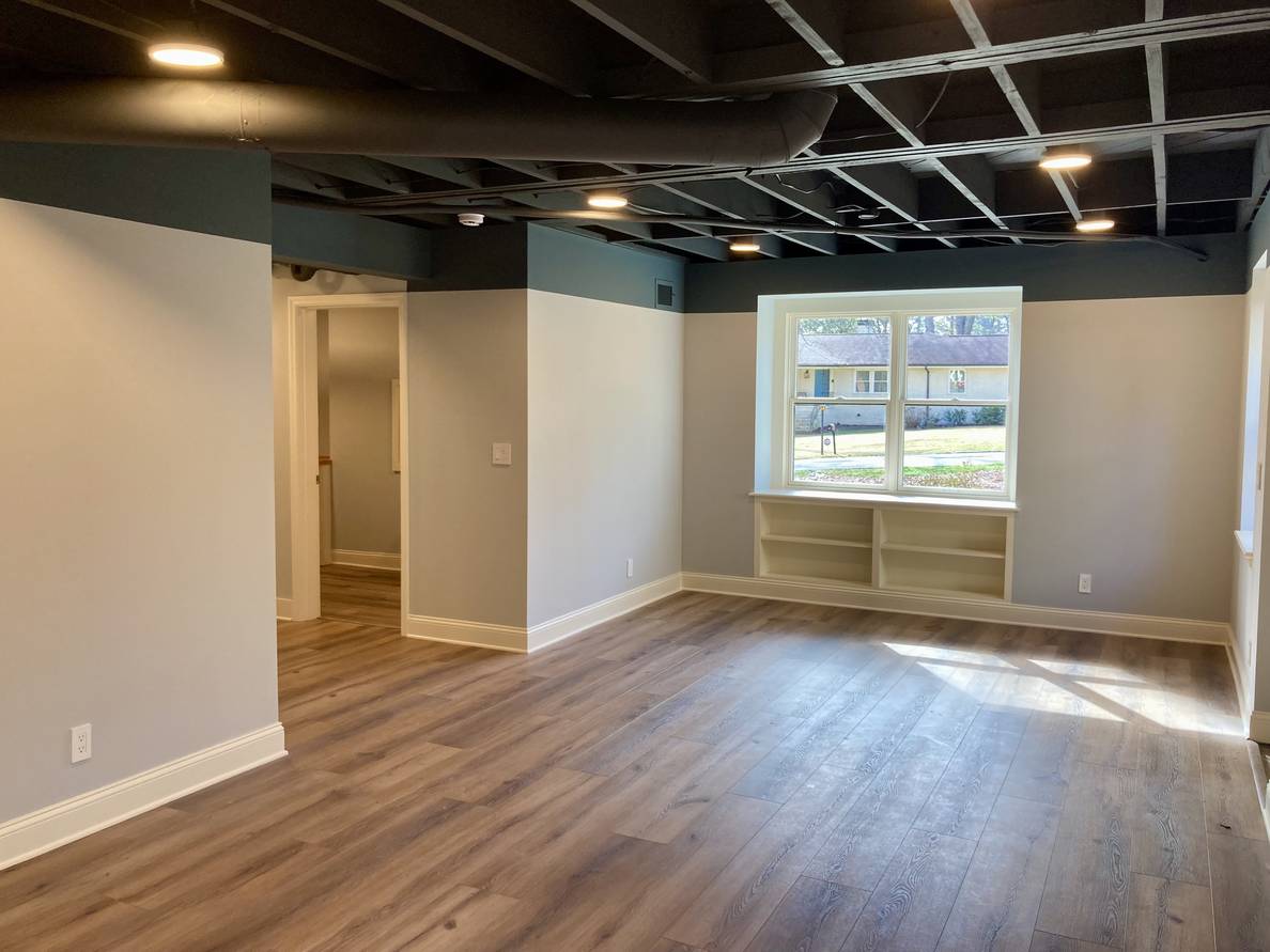 Another photo of the main space from a second angle. From this angle the window to the front yard with the built-in bookshelf is visible as well as the alcove towards the stairs and the door to the laundry room.