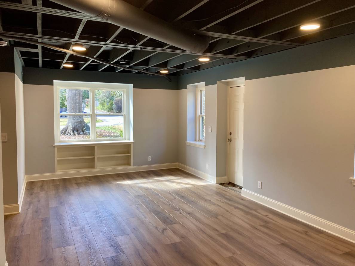 A third photo of the main space from a third angle. From this angle the same window to the front yard is visible as well as a window and door outside to the side of the house.