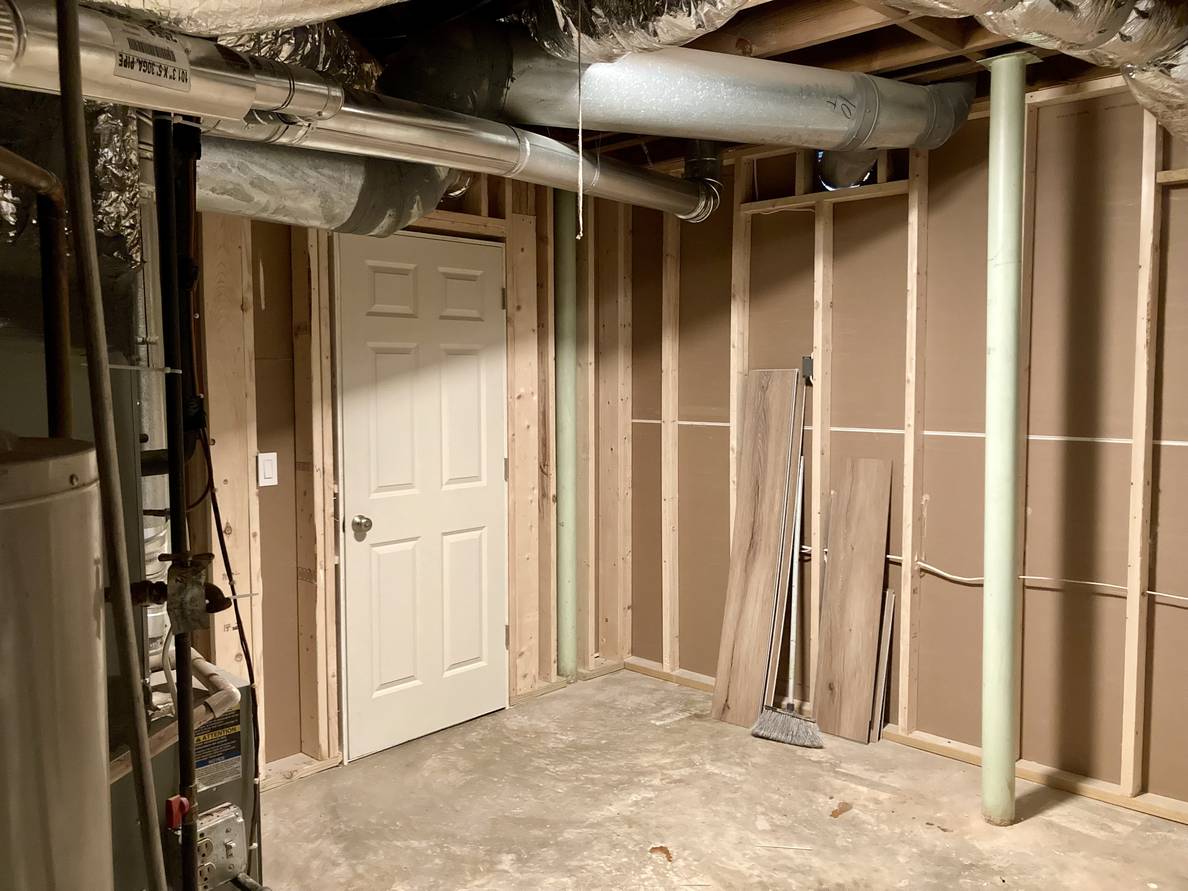 A third photo of the utility room from a third angle. The door is visible from here as well as the unfinished backs of the walls for the finished rooms.