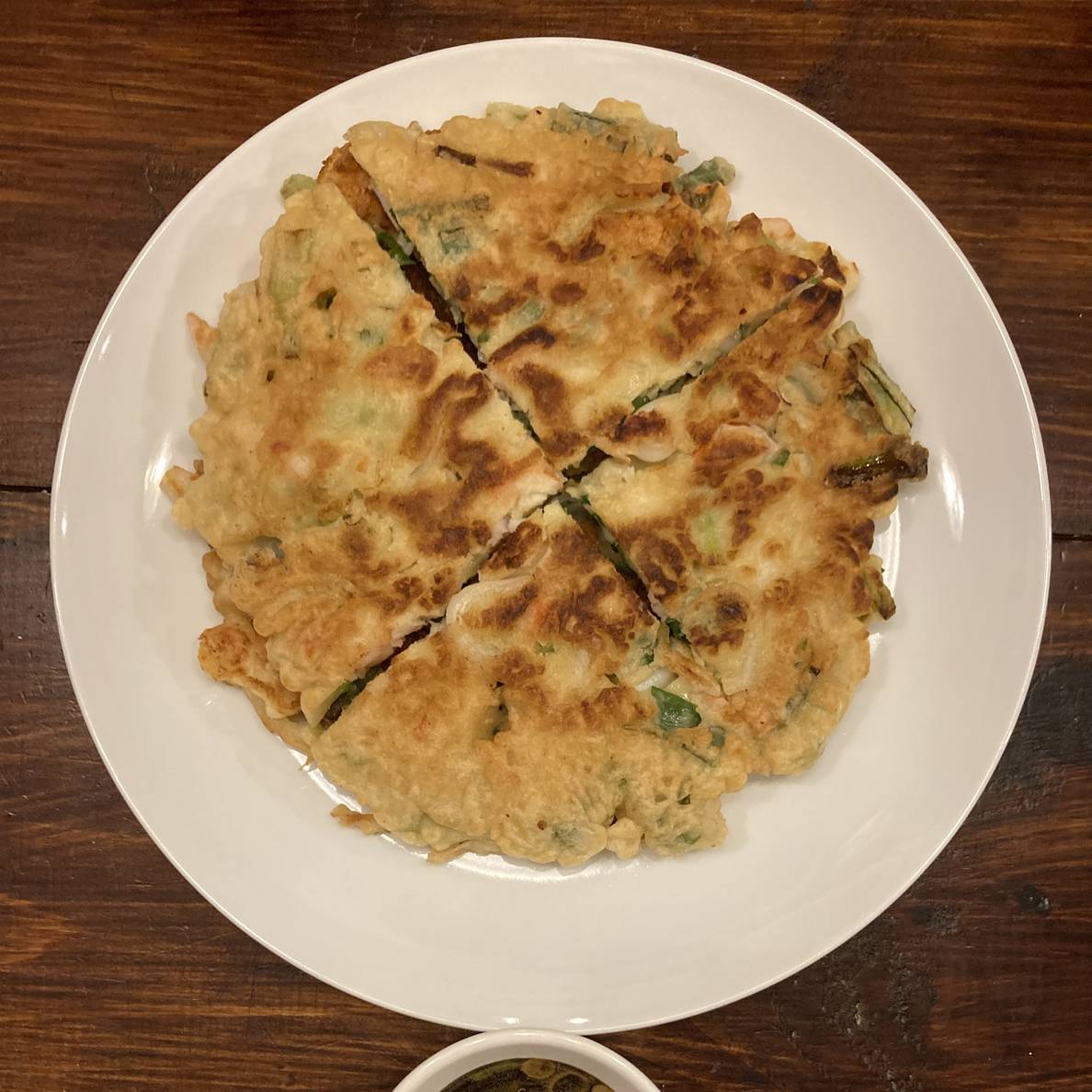 A photo of a plate of korean-style seafood scallion pancakes.