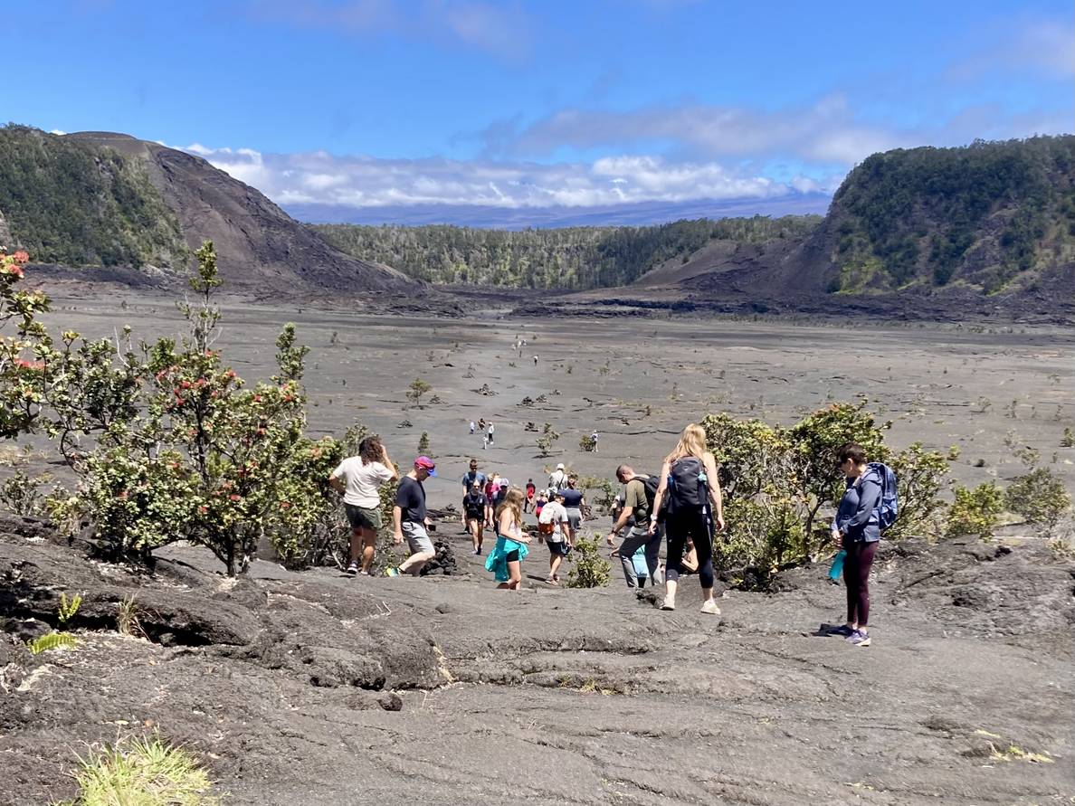 A photo of the first part of the crader, with a bit of descent still left. The crater stretches into the distance with a people dotting a trail through the middle.