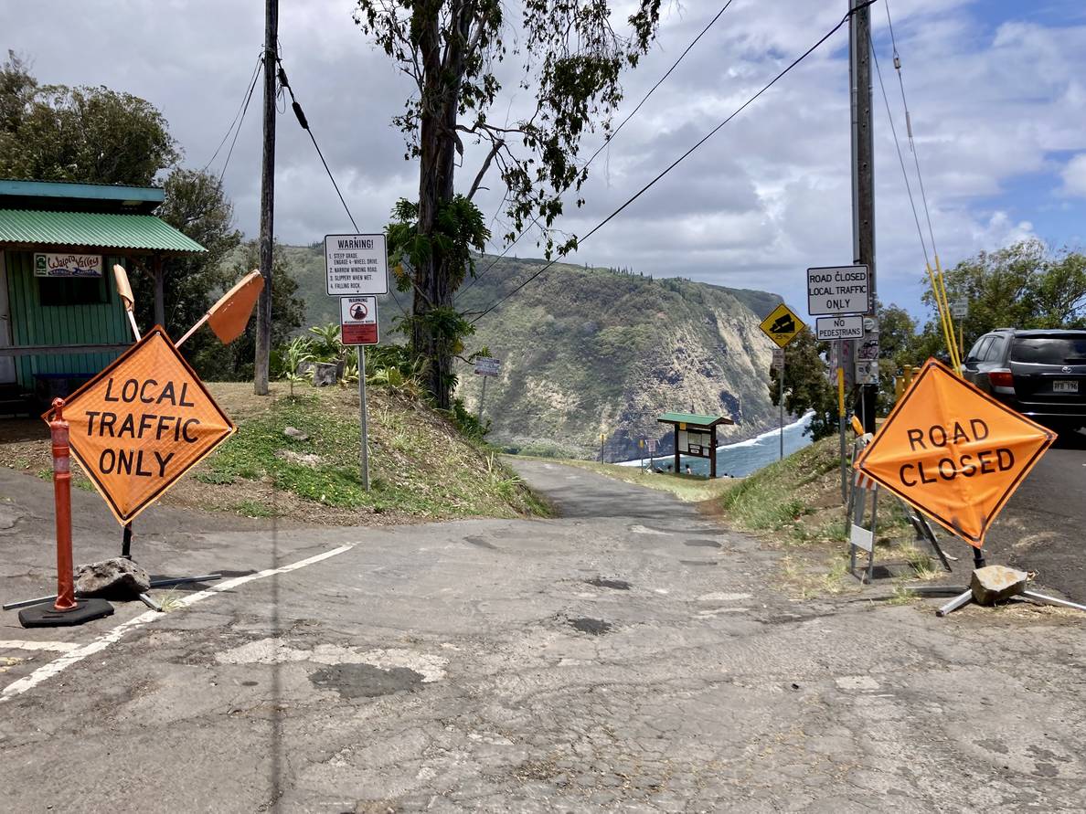 A photo of what appears to be an abrupt end of a street. Signs say “Local traffic only,” “Road closed,” “Warning! 1.Steep grade. Engage 4-wheel drive. 2. Narrow winding road. 3. Slippery when wet. 4. Falling rock.,” and a sign indicating a 25% grade.