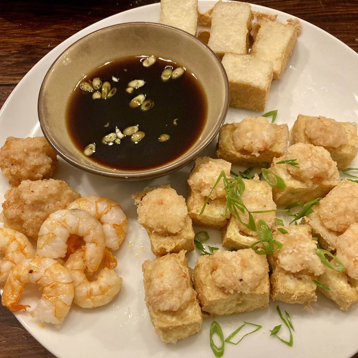 A photo of the plated dish. The shrimp-stuffed tofu is on a plate, garnished with scallions, alongside the dipping sauce, the plain fried tofu, the fried shrimp, and a couple balls of the fried leftover shrimp filling.
