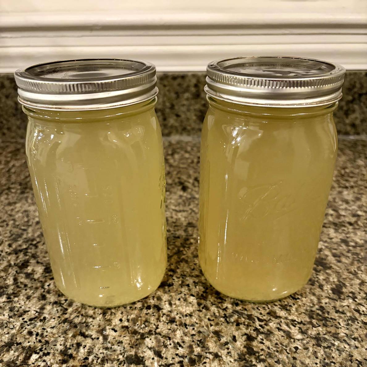 A photo of the stock in two quart-sized jars. It’s a translucent yellow.