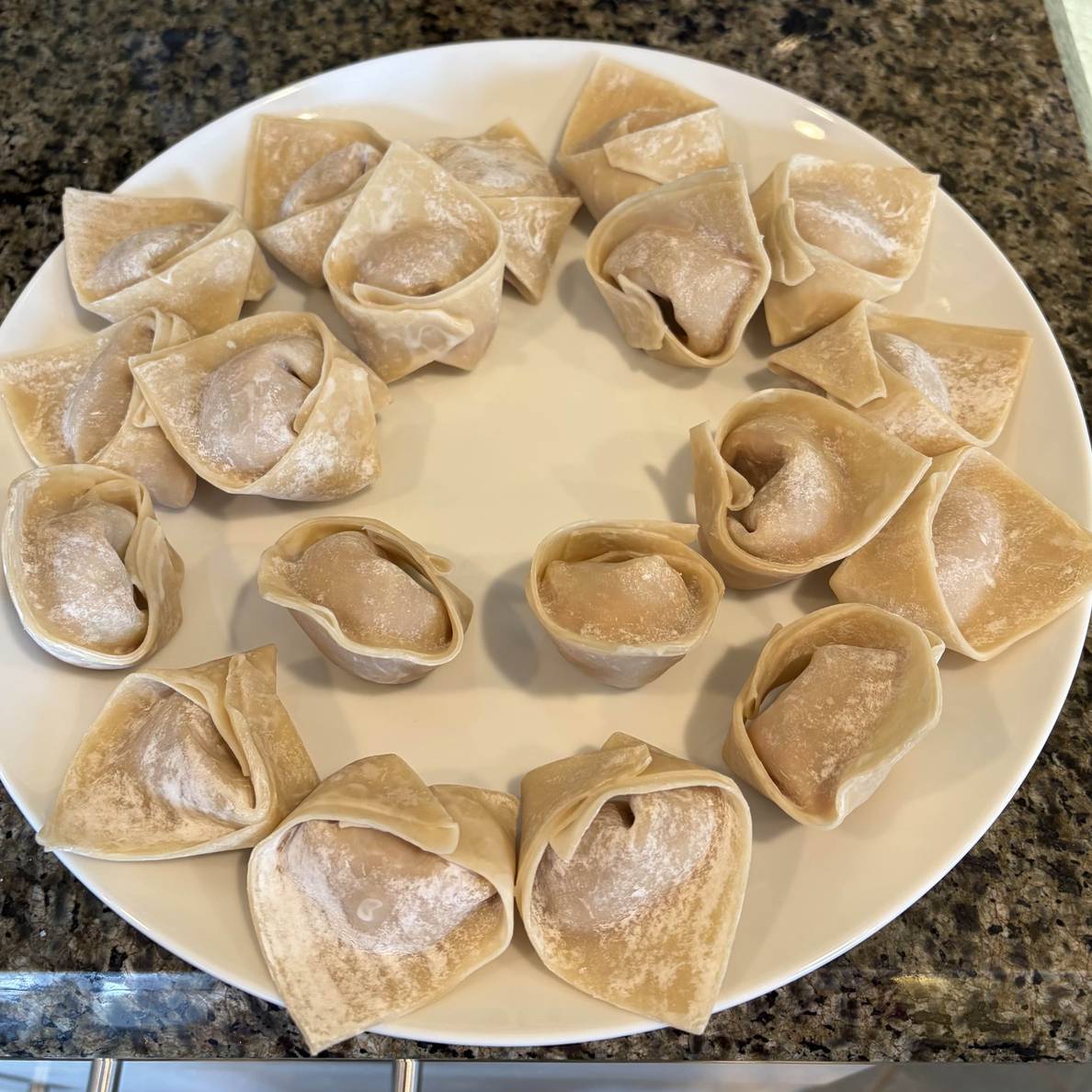 A photo of the wrapped wontons on a plate.